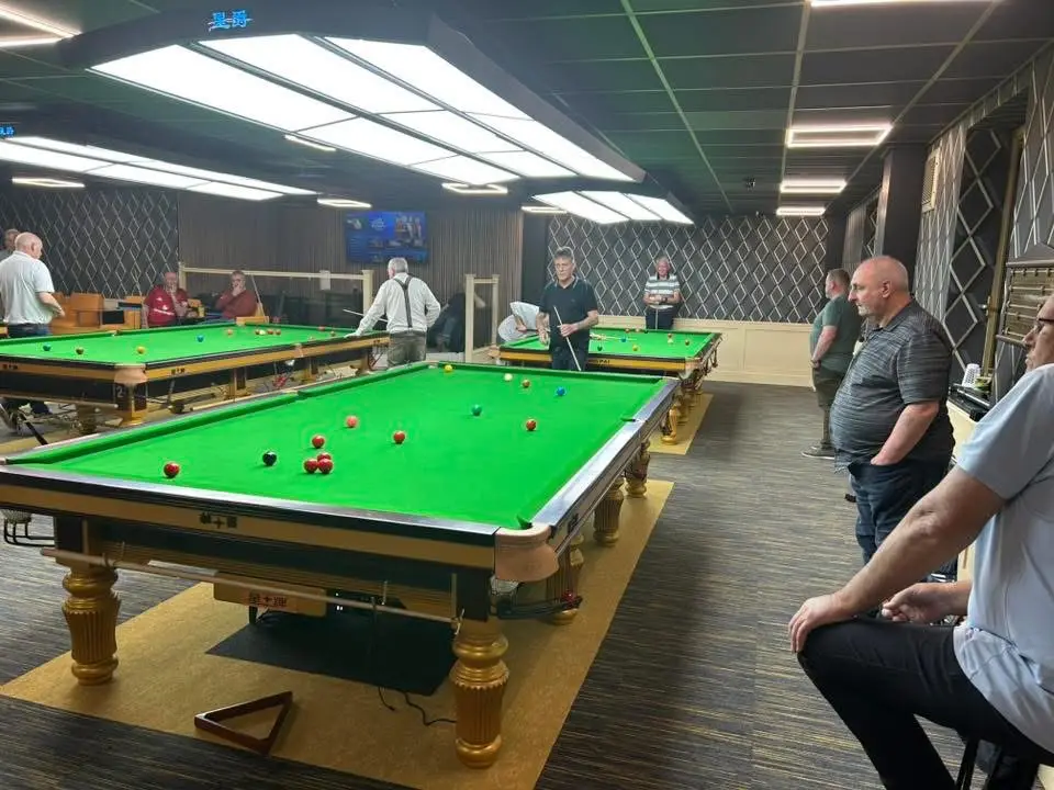 Several matches under way across the room, with spectators watching from seats at the side